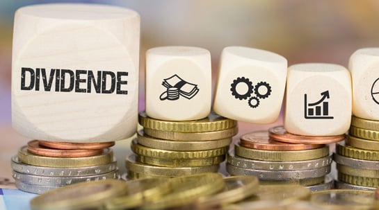 Dividenden-Würfel auf Münzstapel